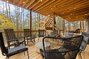 Inviting cabin deck with rocking chairs and seating area overlooking the Kentucky woods. Built by our construction company, this outdoor space offers a perfect blend of nature and comfort.