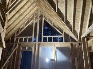 Unfinished cabin construction in Red River Gorge, Kentucky, showcases exposed wood framing, creating a modern, rustic aesthetic. Ideal for short-term rental investment.