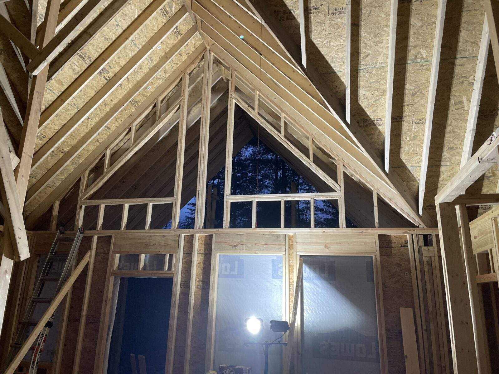 Unfinished cabin construction in Red River Gorge, Kentucky, showcases exposed wood framing, creating a modern, rustic aesthetic. Ideal for short-term rental investment.