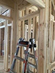 Interior framing of a new cabin or custom home build by our Kentucky construction company. A Little Giant ladder stands amidst the wooden studs, ready for the next phase of construction in the Red River Gorge or beyond.