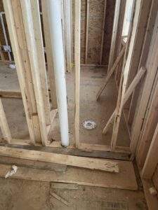 Framing for a new bathroom in a custom built home, showcasing the rough plumbing for a toilet. This construction project by our cabin building company in central Kentucky highlights the initial stages of building a new home.