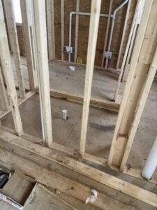 Framing of a new bathroom in a custom built home in Kentucky. Plumbing is visible within the stud walls. Cabin building company constructing a new home.