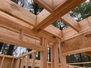 Cabin construction detail showing expertly crafted wooden beams forming the roof structure. This showcases the quality and precision of our cabin building process, a key differentiator from competitors.