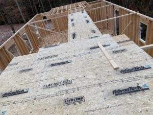 Cabin construction in Red River Gorge, Kentucky. AdvanTech subflooring is being installed on the framed structure. Build your dream cabin with our cabin building company! "Flat Out Best For A Quiet, Stiff Floor" is printed on the subfloor.